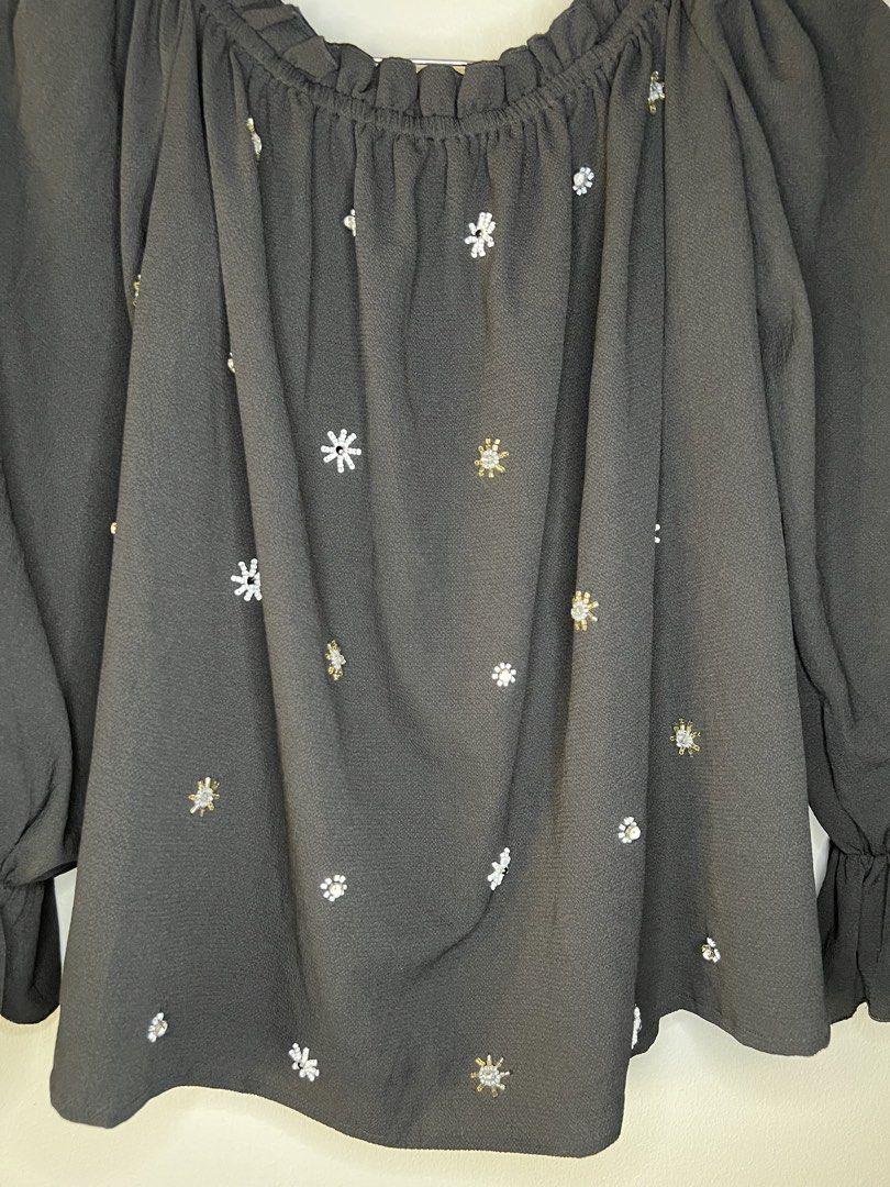 Black Off-Shoulder Blouse with Beaded Snowflake Details (Category: Blouses) located in Quezon City. Submitted by pcera (Listing ID 1436785847, Image 3). Description: - Black off-shoulder blouse - Long sleeves with ruffled cuffs - Ruffled neckline - Delicate snowflake embellishments - Flowy, relaxed fit - Perfect for casual and semi-formal events.