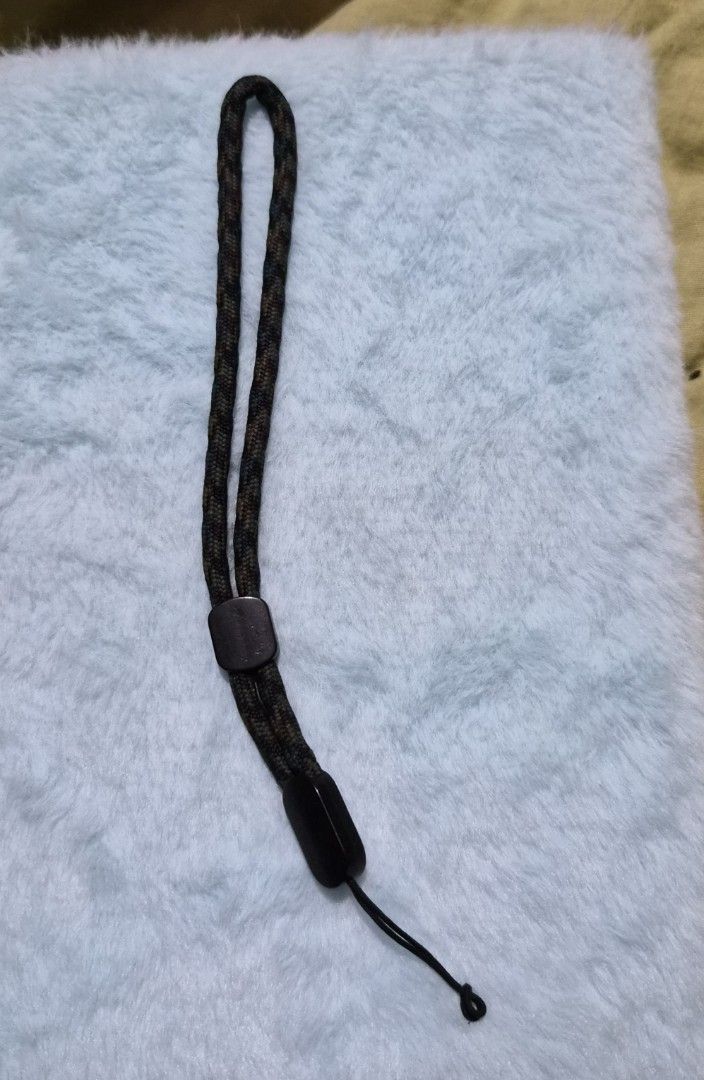 Braided Phone Lanyard (Category: Other Mobile & Gadget Accessories) located in Mandaue City. Submitted by chuchi152615 (Listing ID 1436696187, Image 1). Description: - Braided wrist strap - Black and green camouflage pattern - Features black plastic connectors - Includes a small black string - Durable design - Ideal for cameras and small devices - Provides added security.