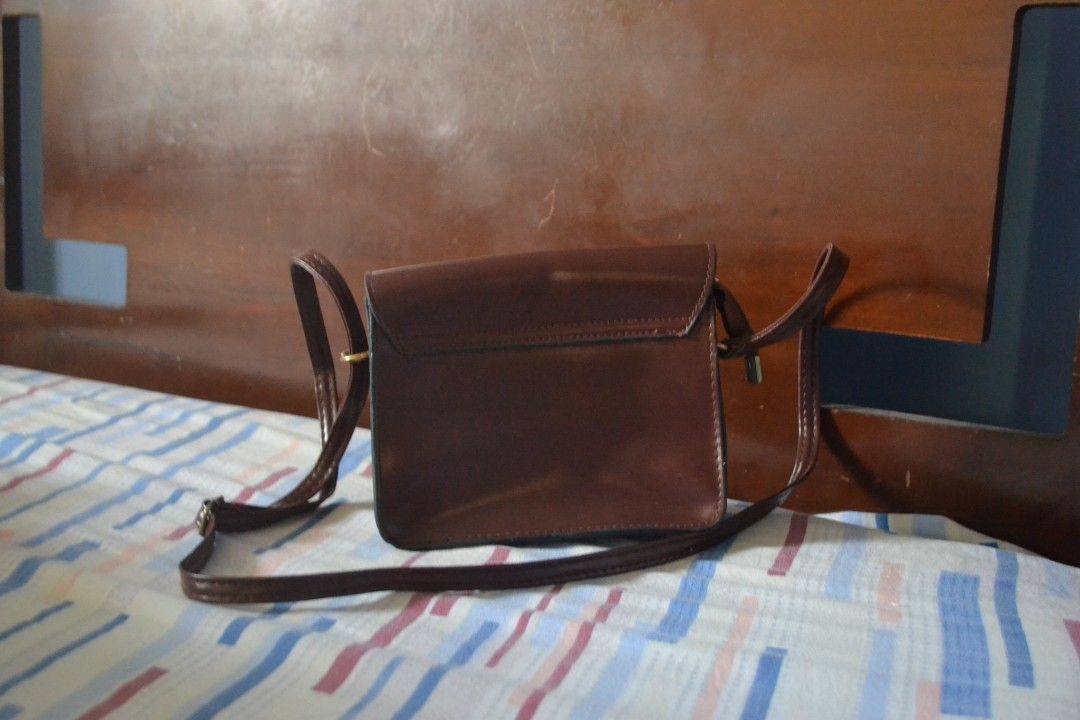 Brown Crossbody Bag (Category: Cross-body Bags) located in Valenzuela. Submitted by miss_merix (Listing ID 1436730799, Image 2). Description: - Brown crossbody bag - Flap closure with buckle - Long strap for shoulder or crossbody wear - Pure leather - From Saudi Arabia - Single main compartment with zipper - Rectangular shape - Darker interior lining.