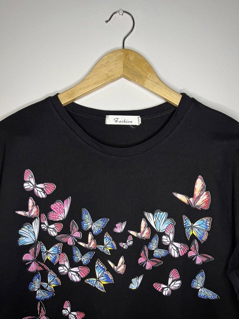 Butterfly Print Black T-shirt (Category: Shirts) located in Quezon City. Submitted by pcera (Listing ID 1436785257, Image 2). Description: - Black t-shirt - Butterfly print (front and back) - Mesh sleeves with ruffle details - Round neckline - 'Fashion' tag.
