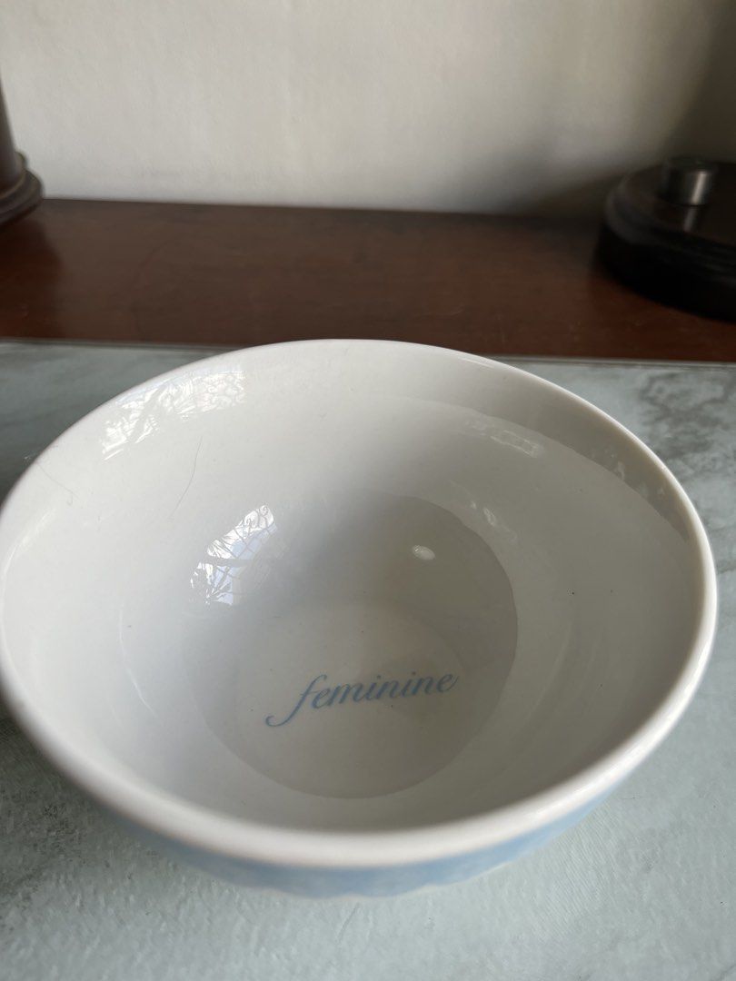 Ceramic Bowl with Blue Lace Design (Category: Dinnerware & Cutlery) located in Taguig. Submitted by minmin_parker (Listing ID 1436767810, Image 3). Description: - Ceramic bowl with a delicate blue lace rim. - Features the word "feminine" inside. - Approximately 5 inches in diameter. - Stands 2.5 inches tall. - Ideal for serving small portions or as a decorative accent..