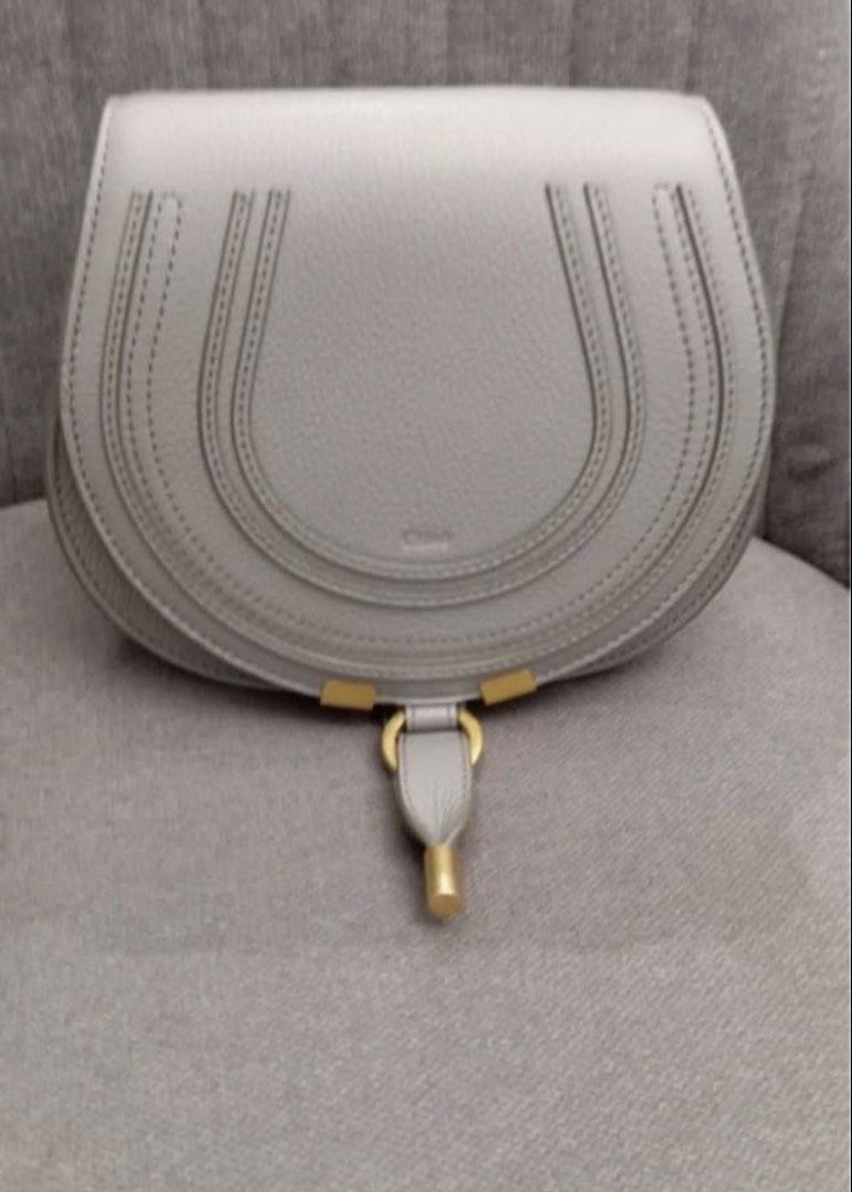 Chloe Marcie mini Crossbody Bag (Category: Luxury Bags & Wallets) located in Manila. Submitted by decluterthings888 (Listing ID 1436813366, Image 2). Description: - Chloe Marcie crossbody bag in gray - Saddle bag design with flap closure - Features gold-tone hardware - Adjustable long strap - Spacious interior - Exterior with stitched detailing - Chloe logo visible - Made of leather.