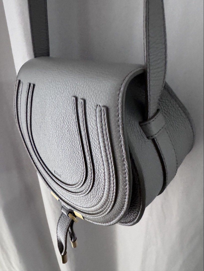 Chloe Mini Marcie Crossbody Bag (Category: Luxury Bags & Wallets) located in Manila. Submitted by decluterthings888 (Listing ID 1436813331, Image 2). Description: - Chloe Marcie Crossbody Bag - Saddle bag design with flap closure - Gray leather exterior - Adjustable long strap - Gold-tone hardware - Tassel detail - Main compartment and interior pocket - Suitable for everyday wear.