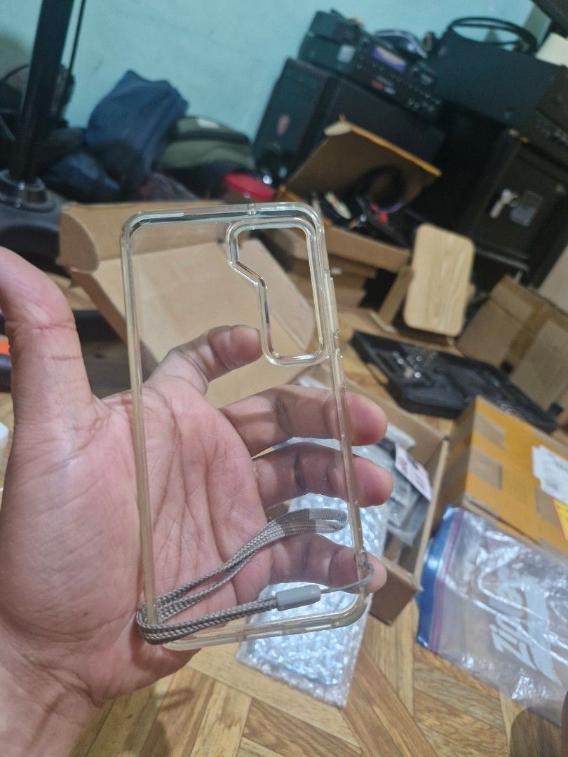 Clear Phone Case with Wrist Strap for s23 (Category: Cases & Sleeves) located in Quezon City. Submitted by kizuke (Listing ID 1436801678, Image 1). Description: - Clear phone case with wrist strap - Made of transparent plastic - Provides basic scratch and impact protection - Specifically designed for [Phone Model] - Features cutouts for camera and phone functions.