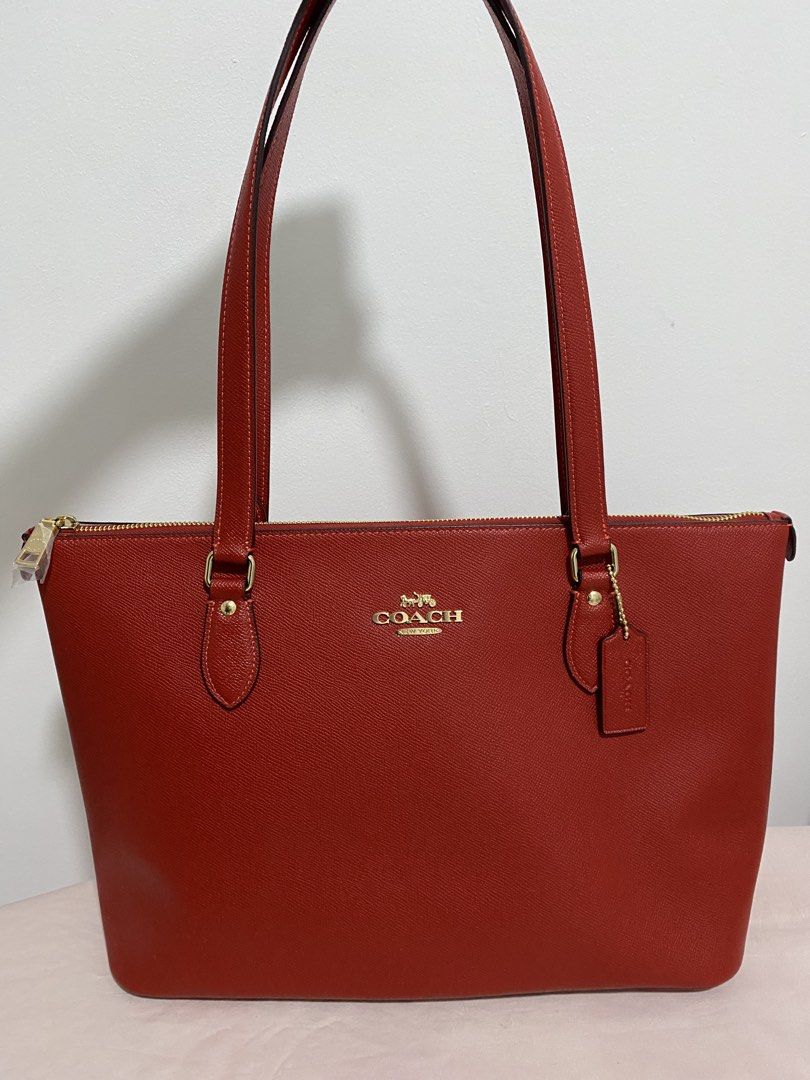 COACH Red Saffiano Carryall Bag (Category: Luxury Bags & Wallets) located in Quezon City. Submitted by wearhouze (Listing ID 1436657865, Image 1). Description: - Authentic Coach Gallery Tote Bag - Color: IM/Bold Red - Features: Zip closure, gold-tone hardware, Coach hangtag - Design: Double top handles, spacious interior - Condition: New with original tag - Made in the Philippines.