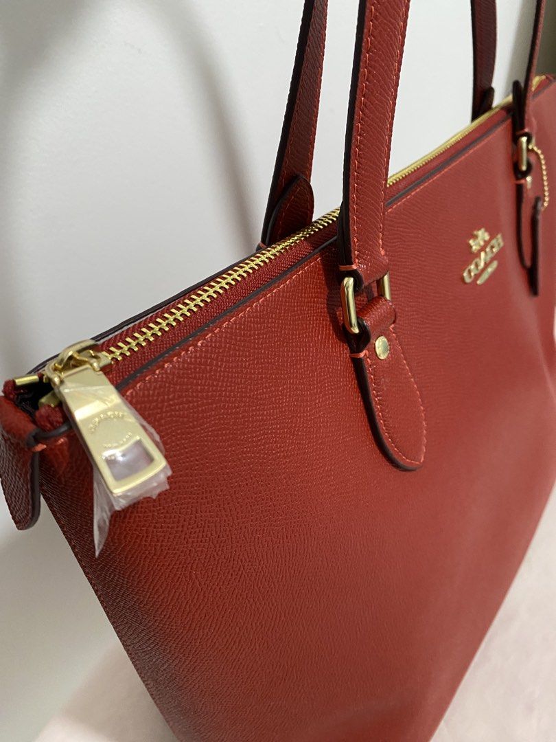 COACH Red Saffiano Carryall Bag (Category: Luxury Bags & Wallets) located in Quezon City. Submitted by wearhouze (Listing ID 1436657865, Image 2). Description: - Authentic Coach Gallery Tote Bag - Color: IM/Bold Red - Features: Zip closure, gold-tone hardware, Coach hangtag - Design: Double top handles, spacious interior - Condition: New with original tag - Made in the Philippines.