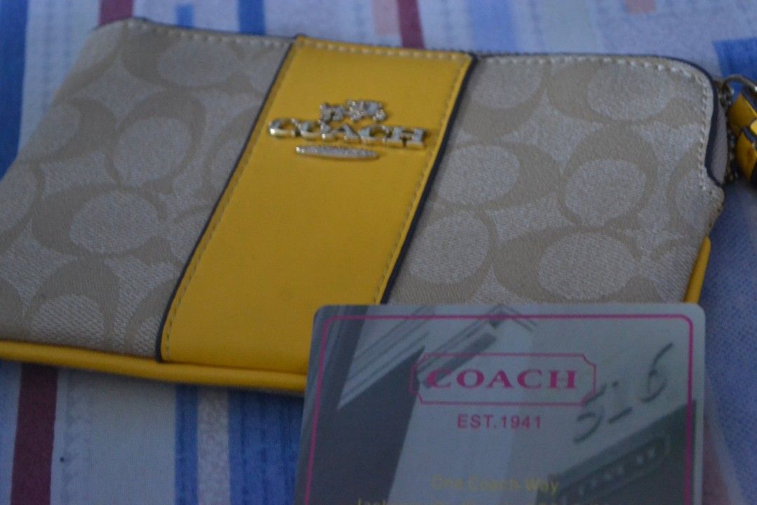 Coach Wristlet with Yellow Accent (Category: Luxury Bags & Wallets) located in Valenzuela. Submitted by miss_merix (Listing ID 1436731544, Image 1). Description: - Authentic Coach wristlet - Signature Coach pattern with yellow accent - Convenient wrist strap - Secure zipper closure - Stylish yellow stripe detail - Features the Coach logo - Includes Coach card.