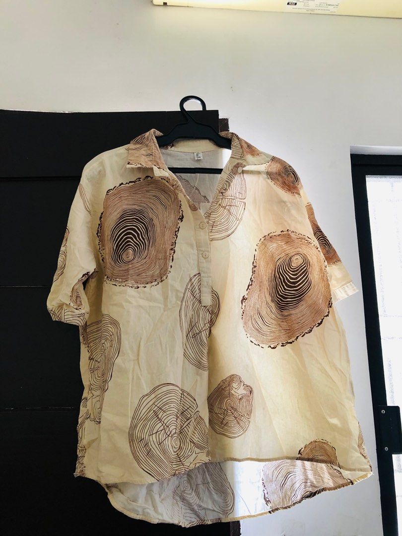 Cream Oversized Wood Grain Print Top (Category: Blouses) located in Las Pinas. Submitted by bibliomomma (Listing ID 1436699674, Image 1). Description: Lightweight cream collared top with an eye-catching wood grain/tree ring print in brown tones. Features a relaxed oversized fit, short sleeves, and partial button-down front for an effortless casual look. Made from breathable fabric that’s comfortable for everyday wear, perfect for pairing with jea