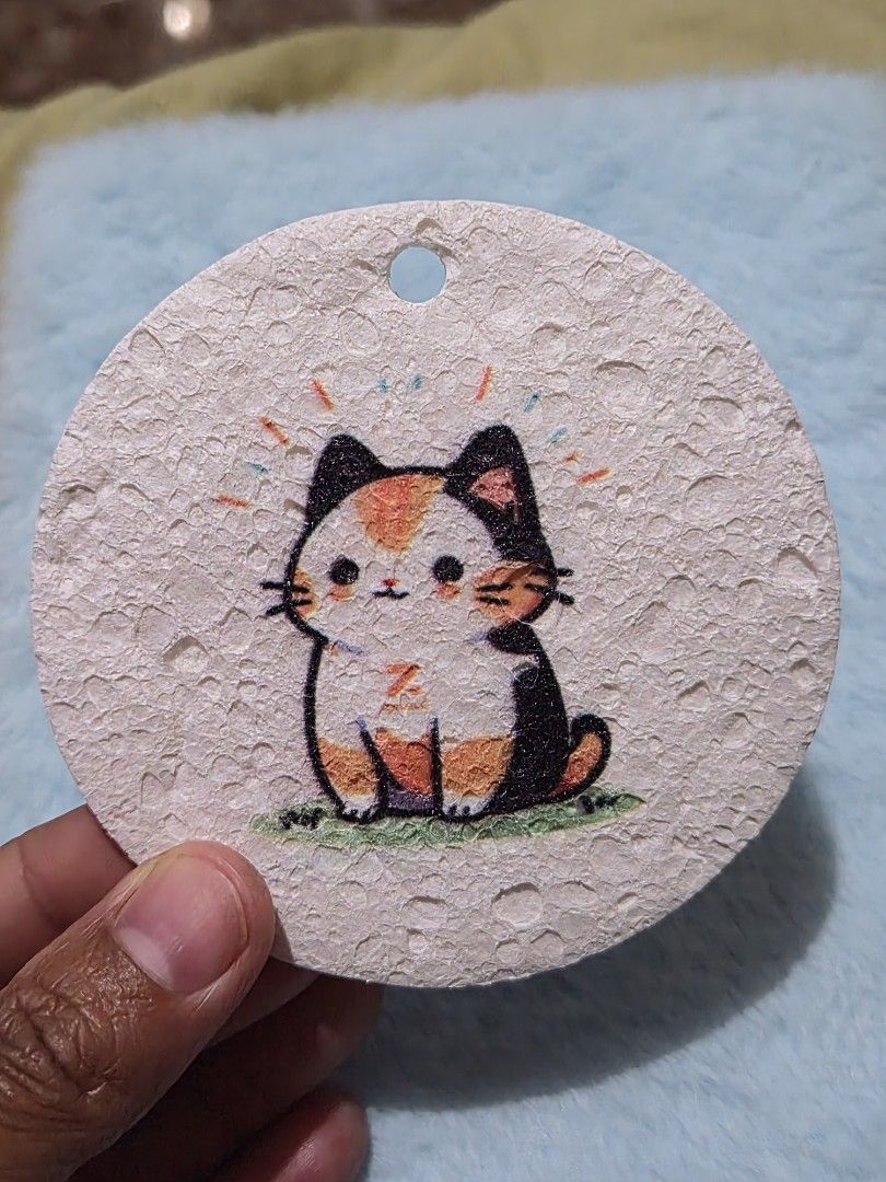 Cute Cat Coaster (Category: Other Kitchenware & Tableware) located in Mandaue City. Submitted by chuchi152615 (Listing ID 1436725670, Image 3). Description: - Adorable cat coaster - Round shape - Textured surface - Features a colorful cat illustration (orange, black, white) - Made of a natural, absorbent material - Includes a small hole.