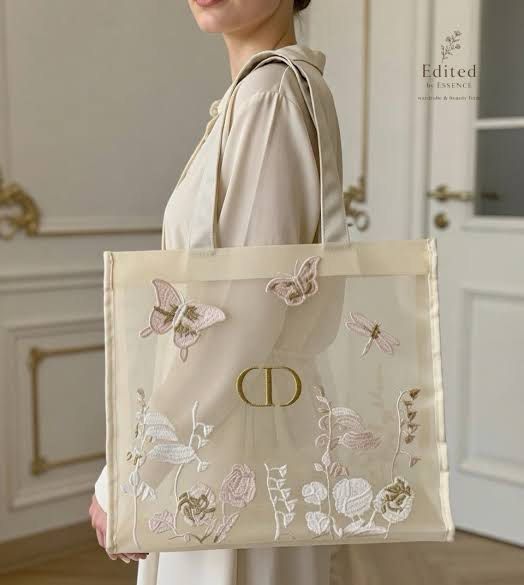 Dior Complimentary Gift Tote Bag (Category: Luxury Bags & Wallets) located in Manila. Submitted by mayserrano16 (Listing ID 1436664127, Image 2). Description: - Dior Gift Tote Bag - Delicate design with embroidered butterflies and floral details - Transparent body - Cream-colored trim and handles - Gold 'CD' logo - Complimentary gift bag.