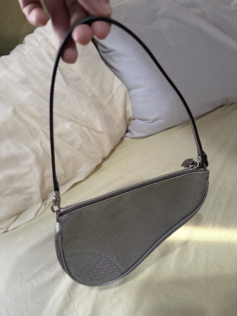 Dior vintage Saddle Bag Silver (Category: Luxury Bags & Wallets) located in Quezon City. Submitted by jujoo (Listing ID 1436775544, Image 2). Description: - Authentic Dior Saddle Bag - Silver with black strap - Dior monogram pattern (NOTE: with black marks/stripped off silver coat) - Curved shape with zipper closure - Silver hardware - Shows wear on edges (NOTE: detached zipper tab, needs glueing).