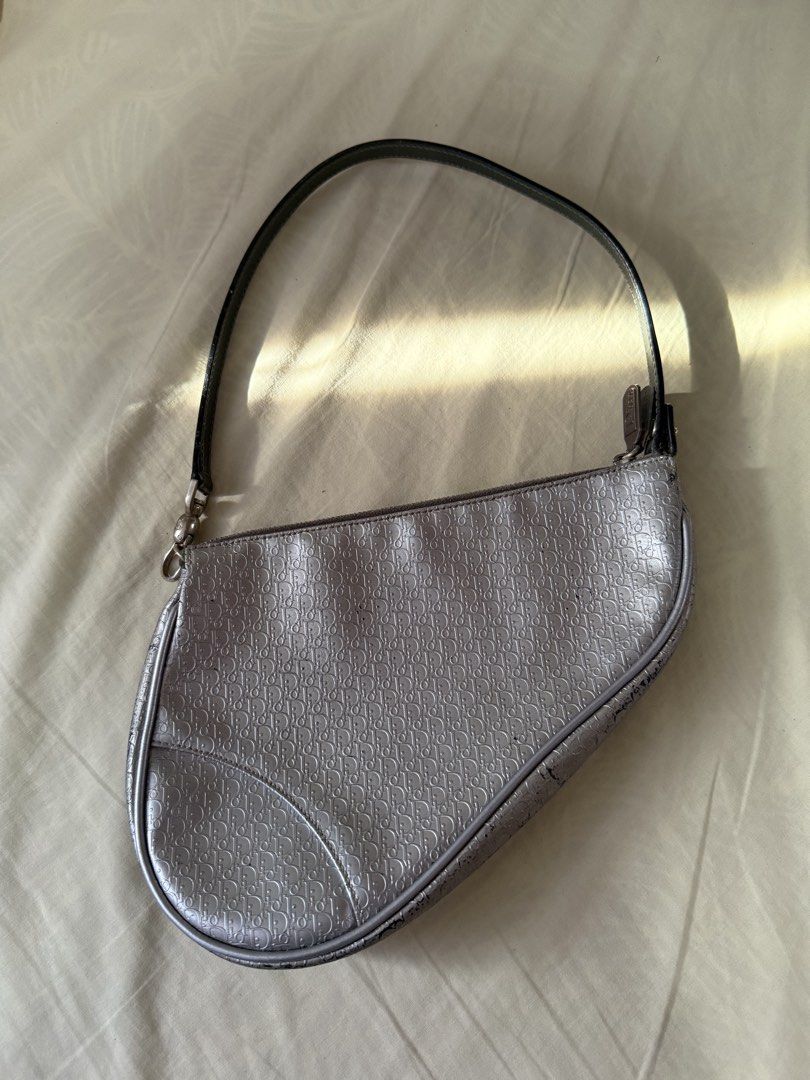 Dior vintage Saddle Bag Silver (Category: Luxury Bags & Wallets) located in Quezon City. Submitted by jujoo (Listing ID 1436775544, Image 1). Description: - Authentic Dior Saddle Bag - Silver with black strap - Dior monogram pattern (NOTE: with black marks/stripped off silver coat) - Curved shape with zipper closure - Silver hardware - Shows wear on edges (NOTE: detached zipper tab, needs glueing).