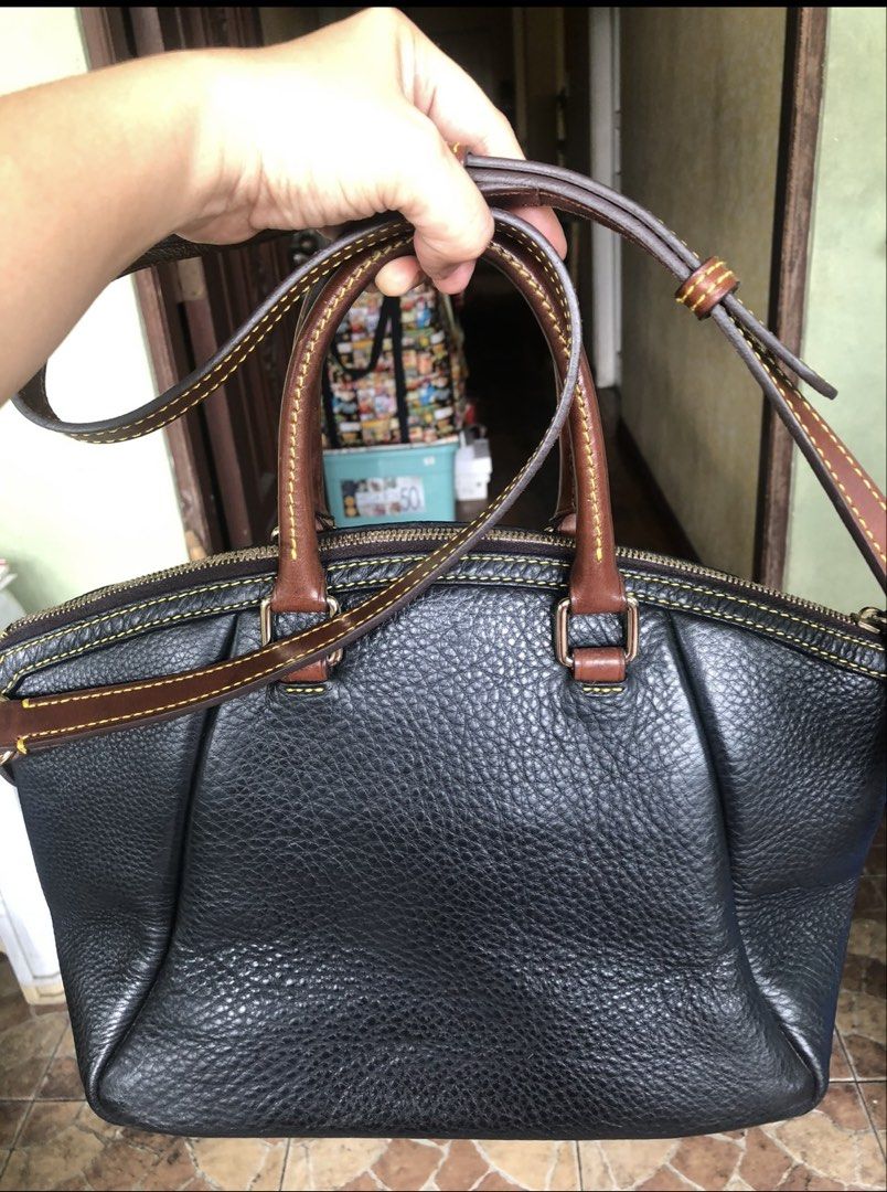Dooney & Bourke Black Leather Handbag (Category: Luxury Bags & Wallets) located in Quezon City. Submitted by cprmob (Listing ID 1436752024, Image 2). Description: Black leather handbag with brown leather accents and stitching. Features a front flap with a buckle closure and a top zipper. Includes a detachable shoulder strap and double handles. The interior is red. The bottom of the bag has brown leather accents. The tag inside the bag has the num
