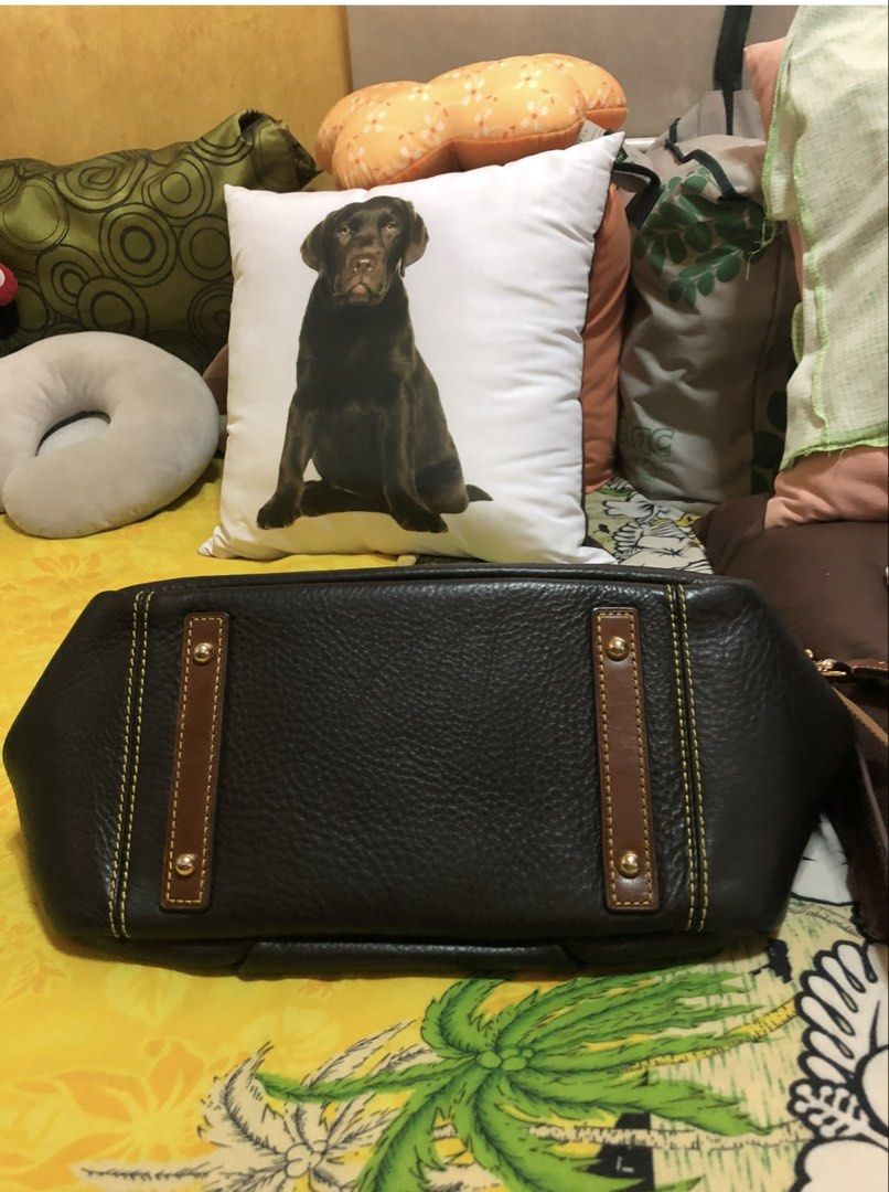 Dooney & Bourke Black Leather Handbag (Category: Luxury Bags & Wallets) located in Quezon City. Submitted by cprmob (Listing ID 1436752024, Image 3). Description: Black leather handbag with brown leather accents and stitching. Features a front flap with a buckle closure and a top zipper. Includes a detachable shoulder strap and double handles. The interior is red. The bottom of the bag has brown leather accents. The tag inside the bag has the num