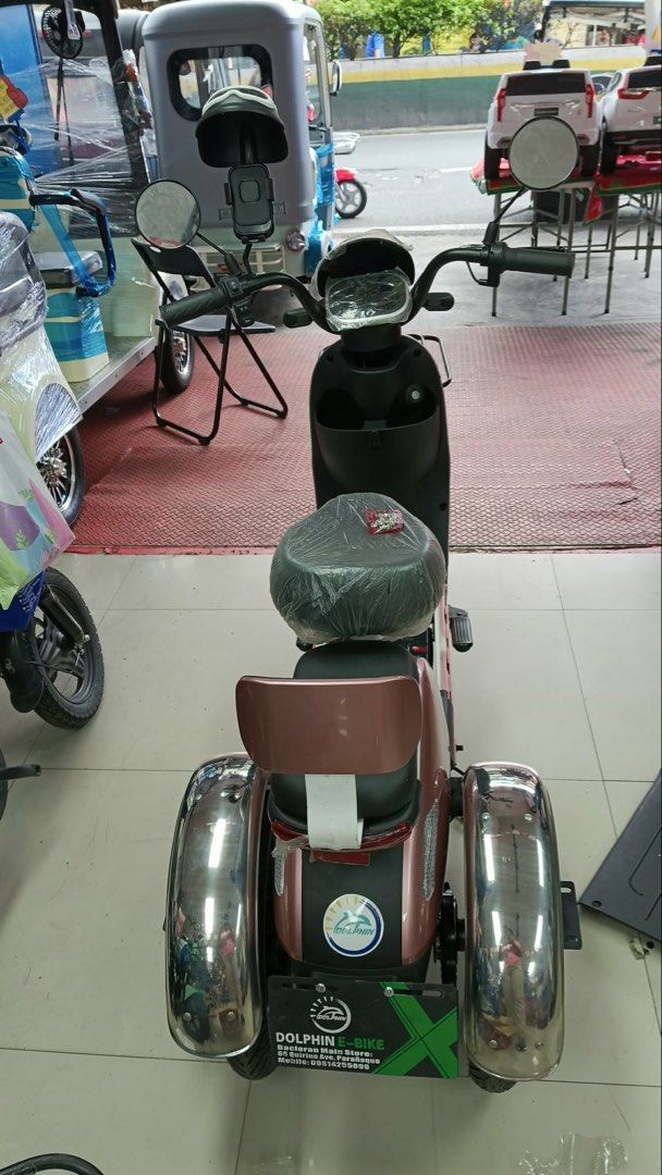 e-bike (Category: Motorbikes for Sale) located in Mandaluyong City. Submitted by brownerr (Listing ID 1436734071, Image 3). Description: SPECIFICATIONS: DOLPHINE EBIKE (DE-CITY UNIT) CUSTOMIZED FROM 2 WHEELS TO 3 WHEELS COLOR: ROSE GOLD BATTERY: FROM 480v12AH UPGRADED TO 480v25AH With Security Alarm PURCHASED DATE: MARCH 11,2026 AMOUNT WHEN PURCHASED: 24,000php including customization SELLING PRICE 22,000php (Negotiable).