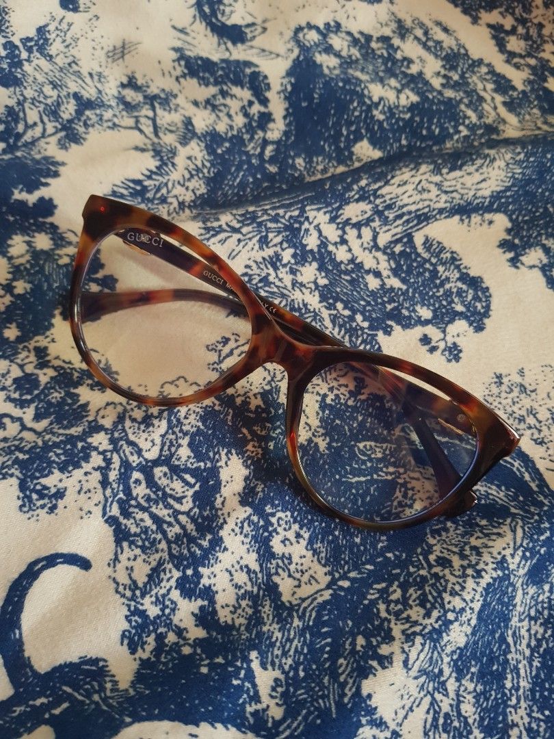 Gucci Eyeglasses (Category: Sunglasses & Eyewear) located in Manila. Submitted by louievicocollections (Listing ID 1436781602, Image 2). Description: - Gucci eyeglasses - Features a tortoise shell frame - Gold-colored accents - Marked with "GUCCI MADE IN ITALY CE" - Size: 52O20-140 - Clear lenses - A stylish and elegant accessory.