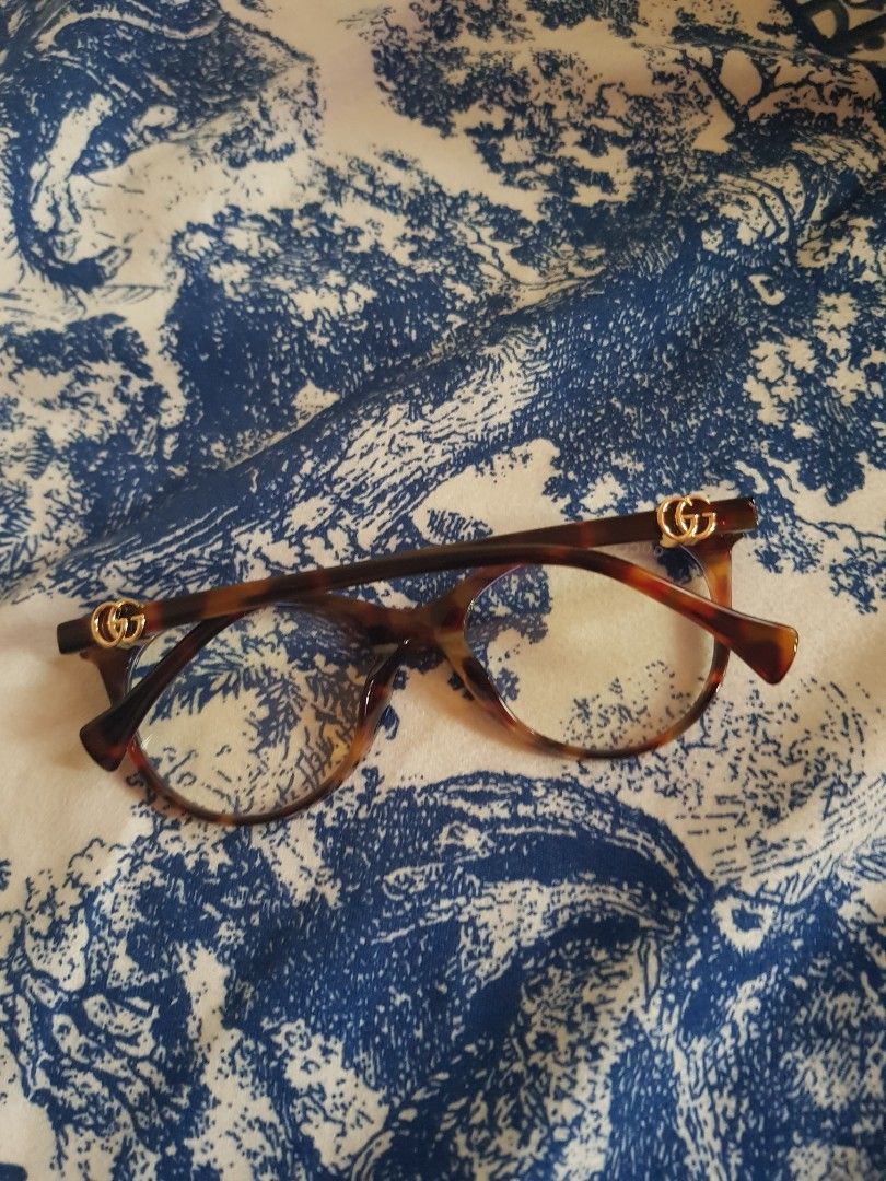 Gucci Eyeglasses (Category: Sunglasses & Eyewear) located in Manila. Submitted by louievicocollections (Listing ID 1436781602, Image 1). Description: - Gucci eyeglasses - Features a tortoise shell frame - Gold-colored accents - Marked with "GUCCI MADE IN ITALY CE" - Size: 52O20-140 - Clear lenses - A stylish and elegant accessory.