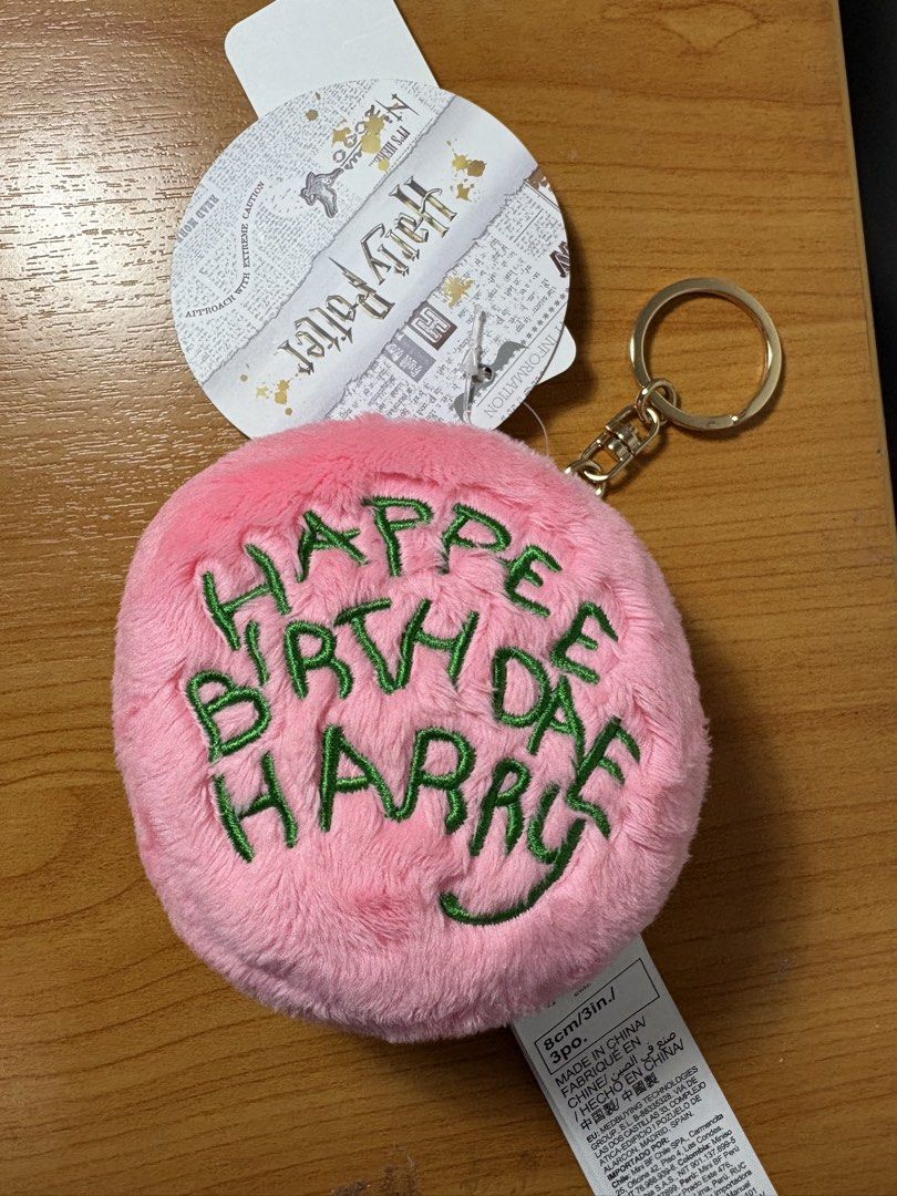 Harry Potter Happy Birthday Keychain (Category: Charms) located in San Fernando. Submitted by sammypgirl (Listing ID 1436804957, Image 1). Description: - Pink, fluffy keychain - Features "Happy Birthday Harry" embroidery - Green embroidery color - Gold-colored keyring - Official Harry Potter merchandise - Includes attached tag.