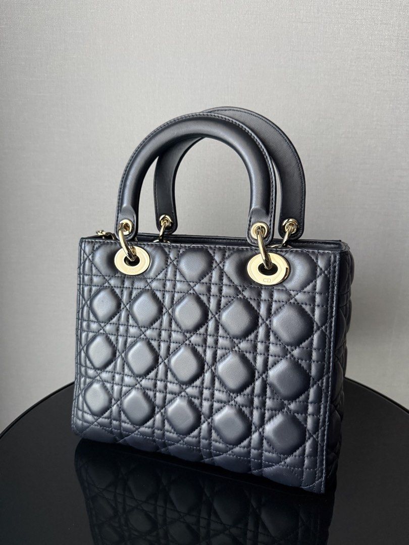 Lady Dior Medium (Category: Luxury Bags & Wallets) located in Quezon City. Submitted by revive.co (Listing ID 1436810531, Image 3). Description: Lady Dior Medium GHW Navy Blue good condition. with signs of usage. zippered version (2019) free bag liner 100% authentic.
