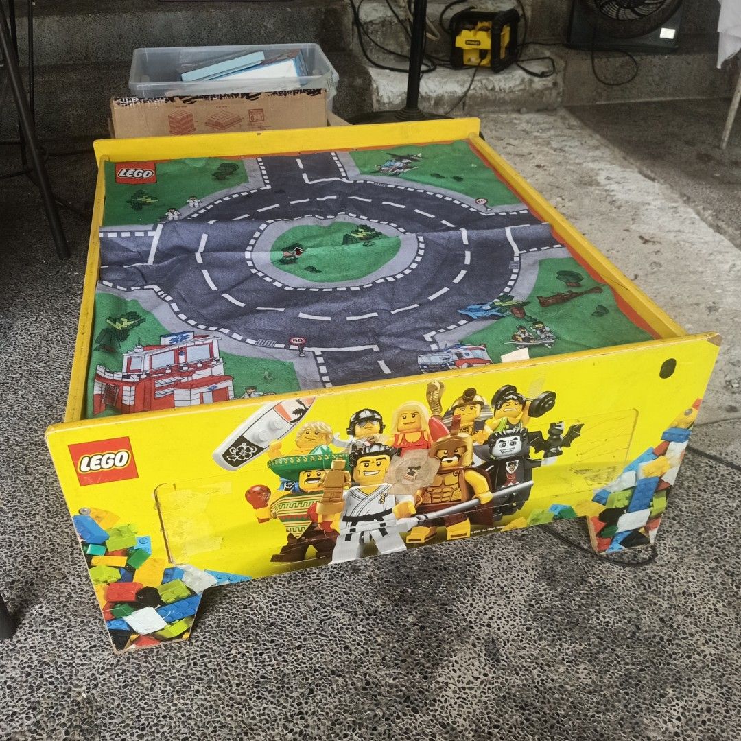 LEGO Play Table with Playmat (Category: Infant Playtime) located in Makati City. Submitted by pardsroman (Listing ID 1436667754, Image 2). Description: - LEGO play table with built-in road playmat - Features a yellow table with LEGO character graphics - Includes a red surface underneath the playmat - Comes with a power outlet - Ideal for kids and their LEGO bricks.