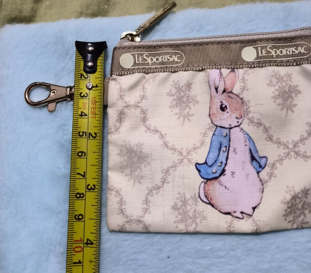 LeSportsac Peter Rabbit Coin Purse (Category: Purses & Pouches) located in Mandaue City. Submitted by chuchi152615 (Listing ID 1436679826, Image 3). Description: - Authentic LeSportsac coin purse - Features a charming Peter Rabbit design - Stylish beige color with a floral pattern - Secure zipper closure - Includes a convenient strap with clasp - Compact and easy to carry - Genuine LeSportsac quality.