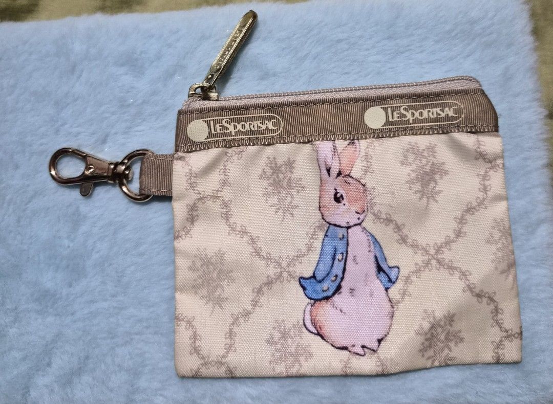 LeSportsac Peter Rabbit Coin Purse (Category: Purses & Pouches) located in Mandaue City. Submitted by chuchi152615 (Listing ID 1436679826, Image 1). Description: - Authentic LeSportsac coin purse - Features a charming Peter Rabbit design - Stylish beige color with a floral pattern - Secure zipper closure - Includes a convenient strap with clasp - Compact and easy to carry - Genuine LeSportsac quality.