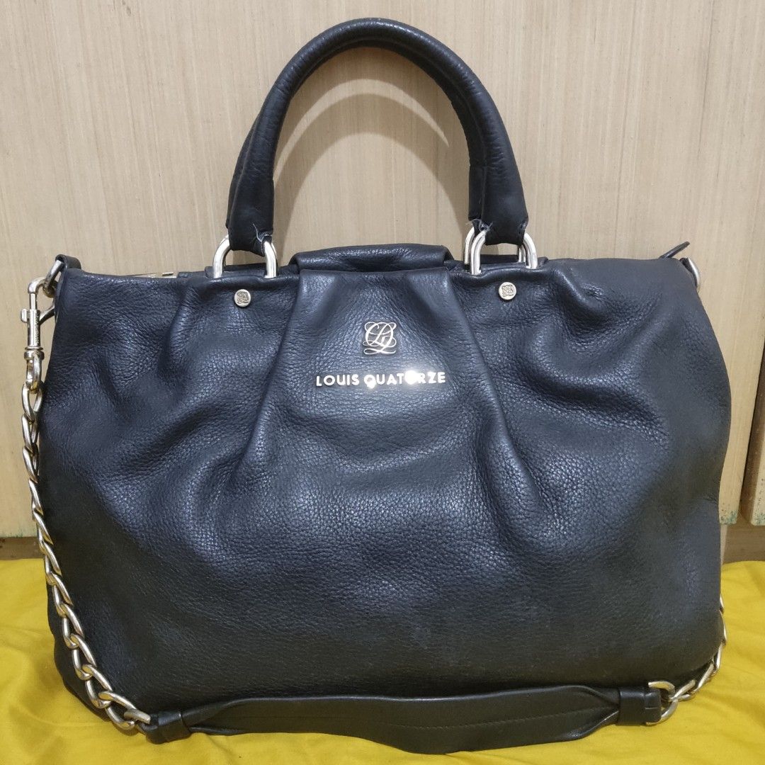 Louis Quatorze Black Handbag (Category: Luxury Bags & Wallets) located in Manila. Submitted by kyabhe (Listing ID 1436806806, Image 1). Description: - Louis Quatorze black handbag - Top handle and chain strap - Interior with patterned lining - Includes a zippered pocket - Brand name visible on exterior and interior - Metal logo on the front.