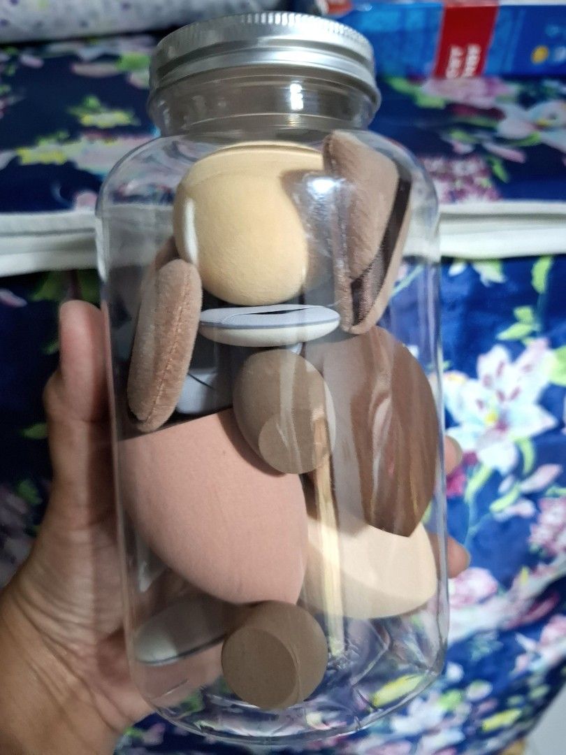 Makeup Sponge and Puff Set in Jar (Category: Makeup) located in Quezon City. Submitted by ana-chan (Listing ID 1436672107, Image 2). Description: - Makeup sponge and puff set - Comes in a clear jar for storage - Includes: - Teardrop sponges - Flat oval sponges - Triangular puffs - Colors: Beige, Brown, Pink - Perfect for applying foundation, concealer, and powder.