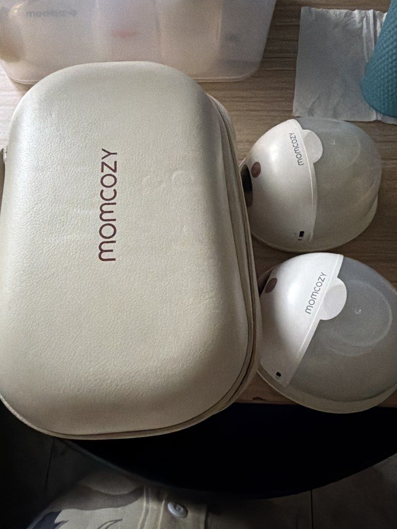 Momcozy Wearable Breast Pump M5 (Category: Breastfeeding & Bottle Feeding) located in Pasig City. Submitted by clairelopez0213 (Listing ID 1436713713, Image 1). Description: - Momcozy wearable breast pump - Includes a carrying case - Two pump units included - Pump units: White with pink accents - Digital display on pump units - Momcozy logo visible - Case features zipper closure and internal compartments **RFS: BF journey ended. Need to declutter