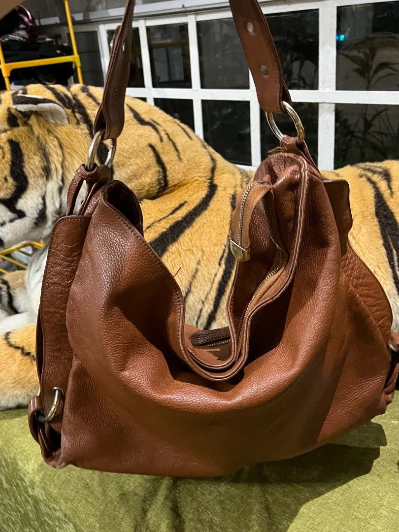 nicole Miller Brown Leather Shoulder Bag (Category: Shoulder Bags) located in Paranaque City. Submitted by annyfd_1102 (Listing ID 1436797287, Image 1). Description: - Brown leather shoulder bag - Spacious interior - Top handle and shoulder strap - Secure zipper closure - Elegant gold-toned hardware - Soft, slouchy design - Perfect for everyday use.