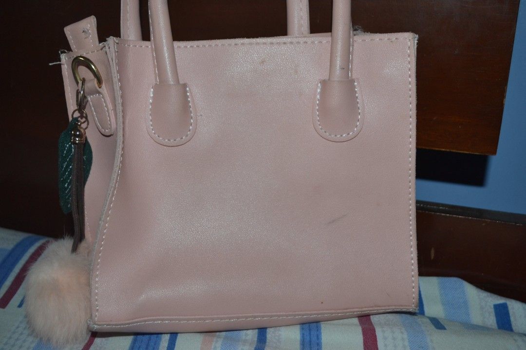 Pink Square Handbag with Pom Pom (Category: Shoulder Bags) located in Valenzuela. Submitted by miss_merix (Listing ID 1436731270, Image 3). Description: - Pink square handbag - Features two handles - Stitched design on the front - Includes a fluffy pom-pom keychain - Zipper closure - Made of smooth material - Stylish and perfect for everyday use.
