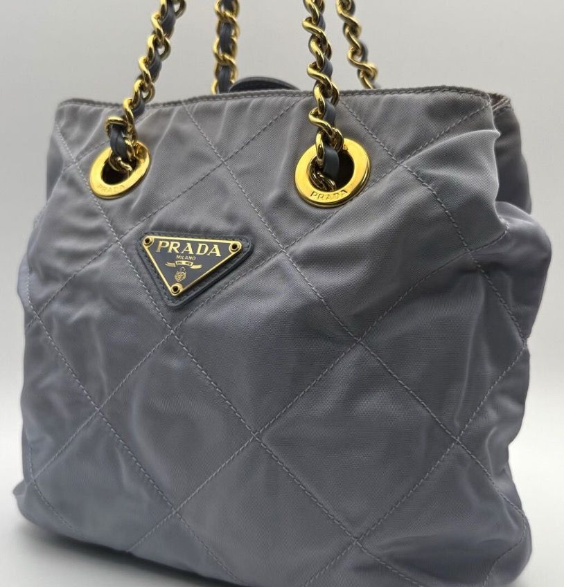 Prada Quilted Chain Shoulder Bag (Rare Color) (Category: Luxury Bags & Wallets) located in Quezon City. Submitted by shopandlearn (Listing ID 1436755732, Image 2). Description: - Authentic Prada handbag - Quilted design - Stylish chain strap (gold & grey leather) - Light blue-grey color - Gold-tone hardware (super clean) - Drawstring closure - Features the iconic Prada triangular logo.