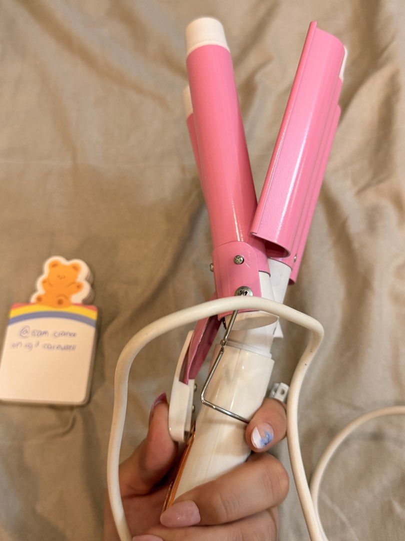 PRELOVED UBEATOR Pink Hair Waver (Category: Hair) located in Manila. Submitted by sam.claree (Listing ID 1436780363, Image 3). Description: PRELOVED Ubeator triple barrel ceramic hair waver in pink and white. - bought from orange app, and Creates beautiful, beachy waves - has three barrels for easy styling (pink and white design) - White cord and standard plug rfs: can no longer use on my hair (i bleached it huhu).