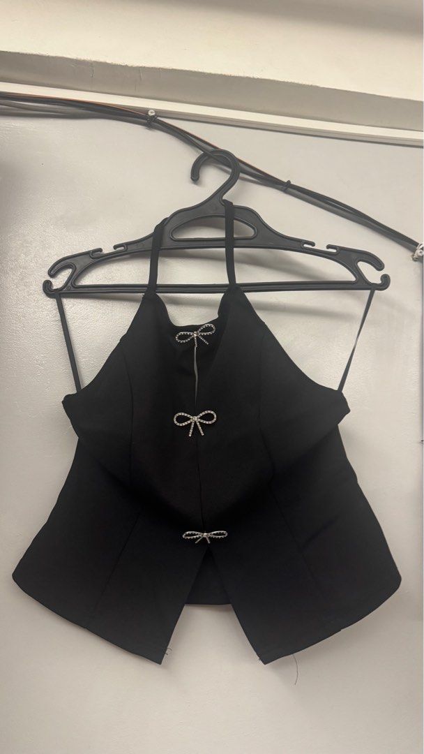 SHEIN Black Halter Top with Bow Details (Category: Sleeveless) located in Cabuyao City. Submitted by edeleezaa (Listing ID 1436733424, Image 1). Description: - SHEIN black halter top - Features bow detail - Size: M (EU 38, US 6) - Material: 95% Polyester - Unique halter neck and split front design - Suitable for special occasions.