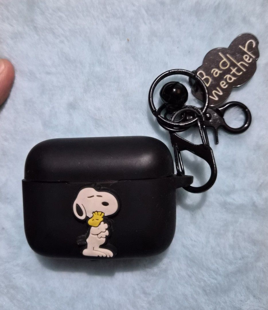 Snoopy AirPods Case with Keychain (Category: Earphones) located in Mandaue City. Submitted by chuchi152615 (Listing ID 1436703791, Image 3). Description: - Black AirPods Pro case - Features a Snoopy design - Includes keychain - Keychain has a "Bad weather?" charm - Matte finish - Attached with a black carabiner clip.