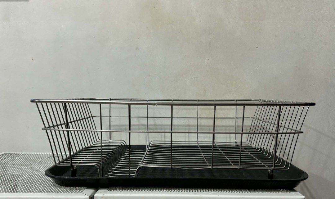 Stainless Steel Dish Rack with Tray (Category: Other Kitchenware & Tableware) located in Quezon City. Submitted by tess1976 (Listing ID 1436715740, Image 2). Description: - Stainless steel dish rack - Includes a black tray - Rectangular shape - Wire frame design - Slots for plates and utensils.