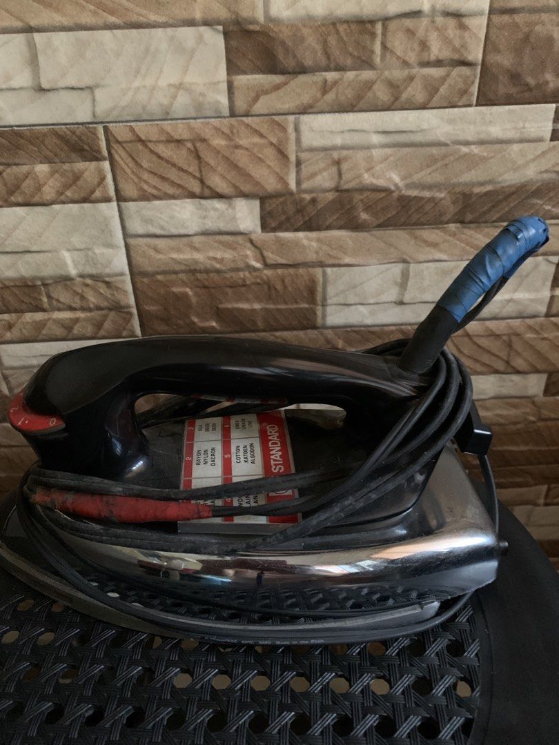 Standard Iron (Category: Irons & Steamers) located in Manila. Submitted by dang8413 (Listing ID 1436769600, Image 1). Description: - Black iron with chrome-plated base - Blue tape-wrapped handle - Temperature control dial - Fabric setting label - Cord included - In working condition.