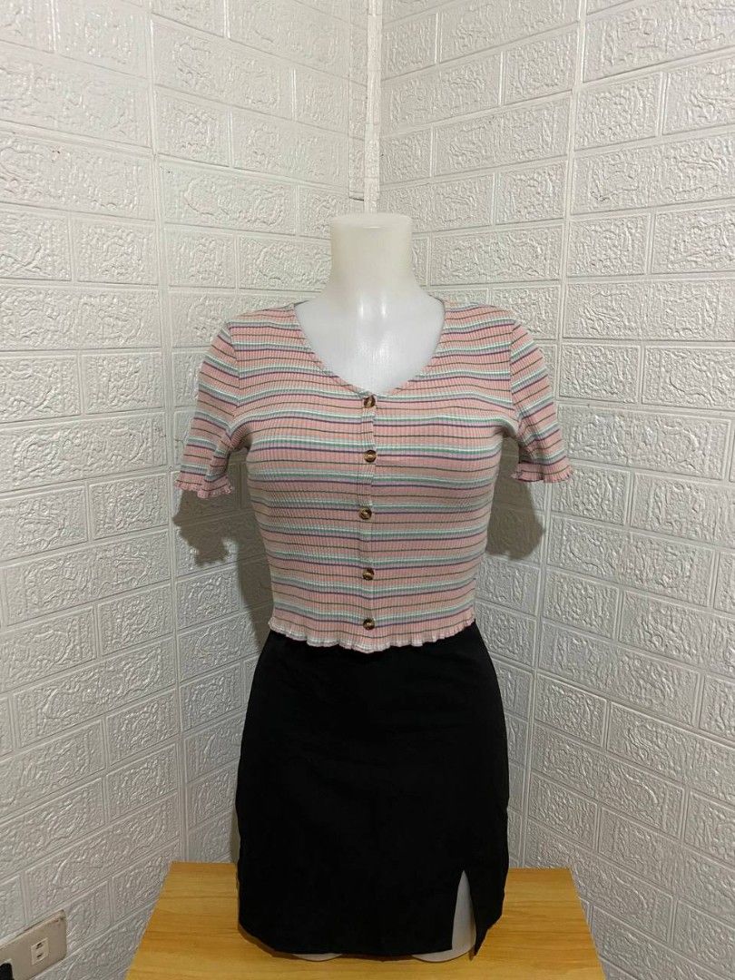 Striped Button-Up Top (Category: Blouses) located in Manila. Submitted by leshmode_ig (Listing ID 1436767101, Image 1). Description: - V-neckline - Button-up design - Short sleeves with ruffled hem - Pink, blue, and white striped pattern - Cropped style - Paired with a black skirt.