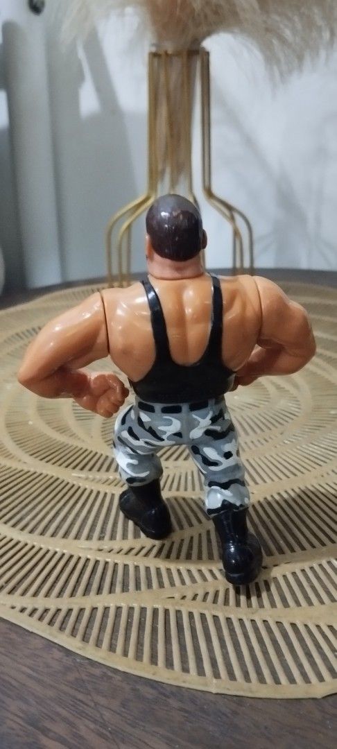 1991 Hasbro WWF Bushwacker Luke action figure (Category: Action & Battle Toys) located in Manila. Submitted by ventajetoyz625 (Listing ID 1436678889, Image 3). Description: - Vintage wrestling action figure - Muscular wrestler design - Black tank top and camouflage pants - Detailed with a beard - Flexing arm pose - Made of plastic - "Gimmick" not working - What you see is what you get.
