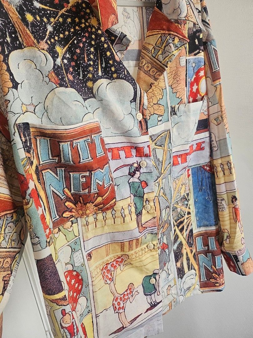 Vintage Graphic Printed Blouse by Audrey Wang (Category: Blouses) located in Quezon City. Submitted by choco_guacamole (Listing ID 1436726616, Image 2). Description: - Vintage Graphic Comic book style print design - Button-down front - Collared neckline - Lightweight fabric - Suitable for warm weather - Features vibrant comic book panels - Relaxed fit - Long sleeves - Size on tag: M 160/34 A .