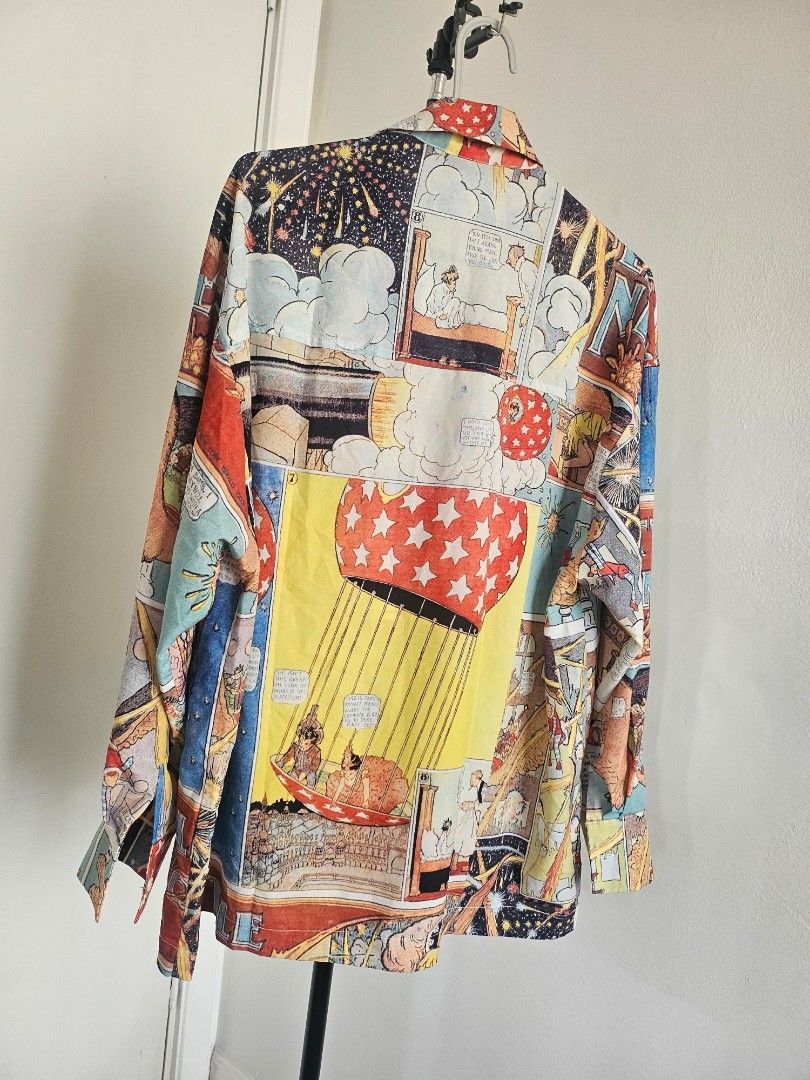 Vintage Graphic Printed Blouse by Audrey Wang (Category: Blouses) located in Quezon City. Submitted by choco_guacamole (Listing ID 1436726616, Image 3). Description: - Vintage Graphic Comic book style print design - Button-down front - Collared neckline - Lightweight fabric - Suitable for warm weather - Features vibrant comic book panels - Relaxed fit - Long sleeves - Size on tag: M 160/34 A .