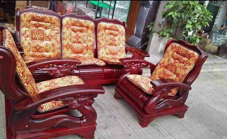 Vintage Wooden Sofa Set (Category: Sofas) located in Manila. Submitted by lykcacamacho (Listing ID 1436734973, Image 1). Description: - solid wood sofa set - Includes a three-seater sofa and two armchairs - Features dark wood with intricate carvings - Cushions upholstered in patterned fabric - Warm tones - Ideal for living rooms.