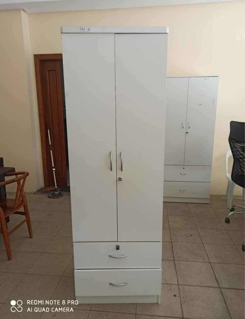 White Wooden Wardrobe with Drawers (Category: Shelves, Cabinets & Racks) located in Manila. Submitted by lykcacamacho (Listing ID 1436679350, Image 2). Description: - White wooden wardrobe - Two doors - Two drawers with silver handles - Includes a hanging rod - Tall and rectangular design - Ideal for storing clothes and other items - Made of wood CASH ON DELIVERY VIA LALAMOVE 09664010899 / 09385133266.