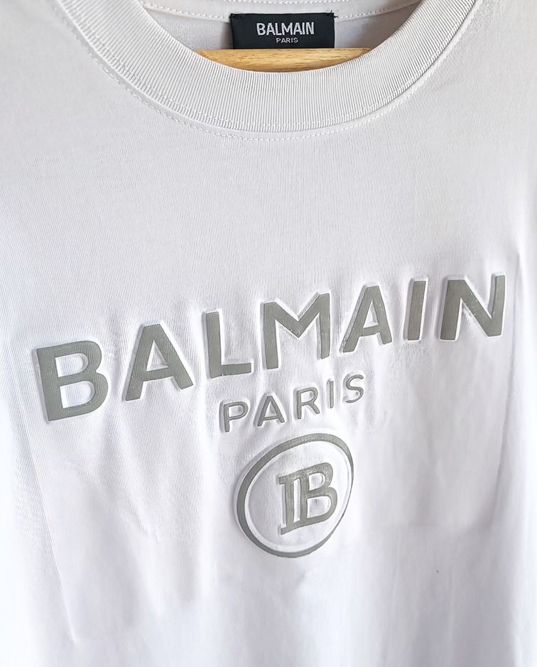 Balmain Paris White T-shirt (Category: Tshirts & Polo Shirts ) located in Guagua. Submitted by retro_finds25 (Listing ID 1436981428, Image 3). Description: Balmain Paris T-shirt - Size: 22 x 27 - Color rate 9/10 - Features the iconic Balmain logo - Made in France - Fabric: 100% cotton - Style: Crew neck, short sleeves - Size: Not indicated.