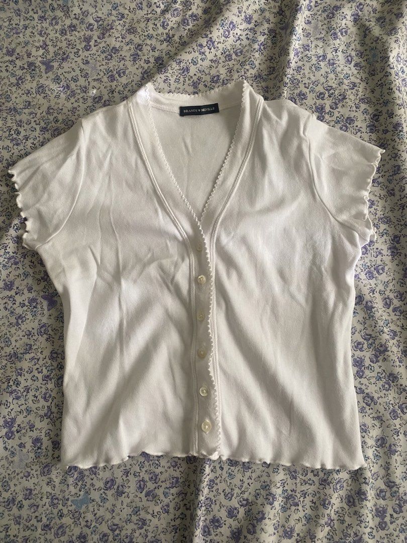 Brandy Melville White Cardigan Top (Category: Others Tops) located in Lila. Submitted by atfnya (Listing ID 1436904638, Image 2). Description: - Brand: Brandy Melville - Style: Cardigan top - Color: White - Features: V-neck, short sleeves, scalloped trim, button-up front - Style: Cropped - Material: Soft, lightweight fabric.