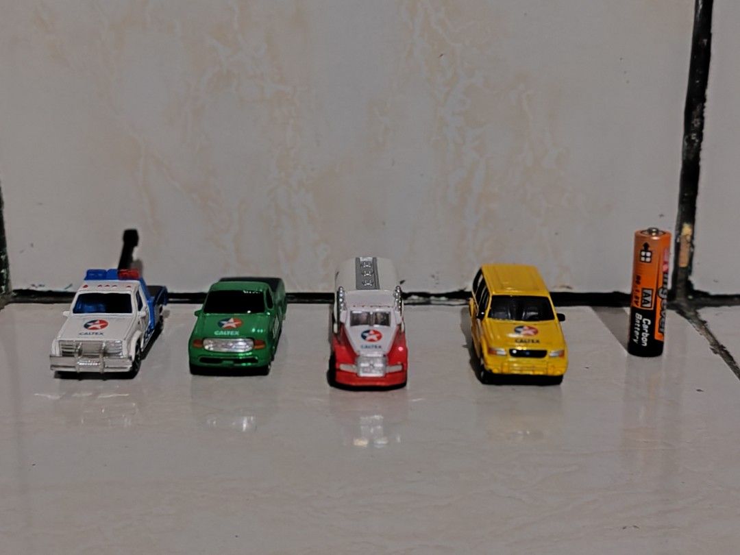 Caltex Toy Cars Set (Category: Vehicle & Diecast Models) located in Pasig City. Submitted by geraldnee28280 (Listing ID 1436990643, Image 2). Description: - Includes four miniature toy cars: - White and blue tow truck - Green pickup truck - Red and white Caltex tanker truck - Yellow station wagon - All cars have wheels. - Made of metal and plastic..