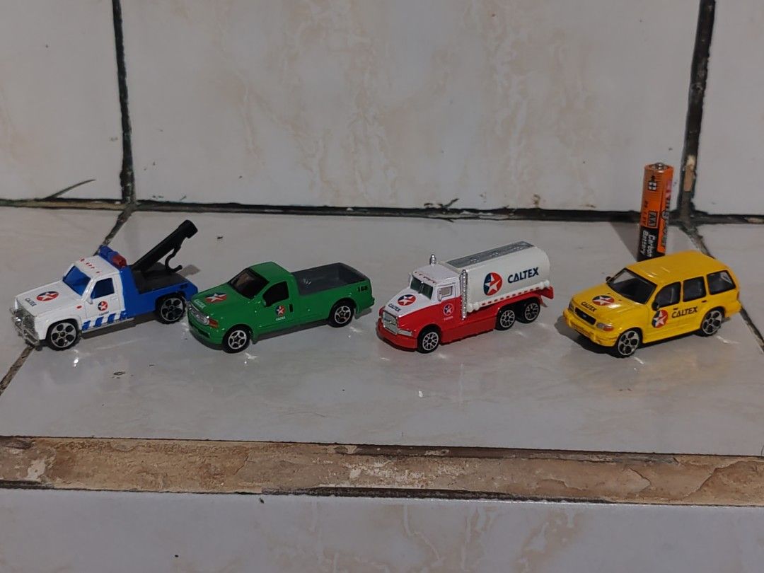 Caltex Toy Cars Set (Category: Vehicle & Diecast Models) located in Pasig City. Submitted by geraldnee28280 (Listing ID 1436990643, Image 1). Description: - Includes four miniature toy cars: - White and blue tow truck - Green pickup truck - Red and white Caltex tanker truck - Yellow station wagon - All cars have wheels. - Made of metal and plastic..