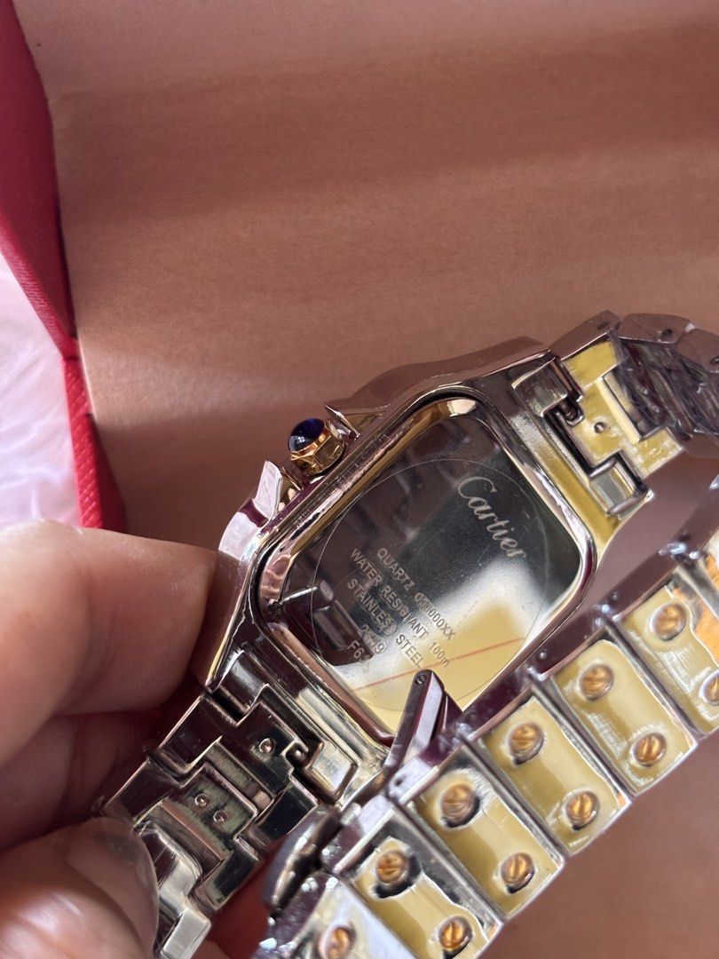 Cartier Santos Two-Tone Watch (Category: Luxury Watches) located in Cebu City. Submitted by day.98 (Listing ID 1435471188, Image 3). Description: - Japan watch -Cartier Santos watch - Two-tone design: gold bezel and accents, silver bracelet - Cream-colored dial - Roman numeral hour markers - Includes original red Cartier box - Classic and luxurious timepiece.