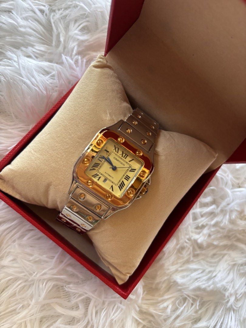 Cartier Santos Two-Tone Watch (Category: Luxury Watches) located in Cebu City. Submitted by day.98 (Listing ID 1435471188, Image 2). Description: - Japan watch -Cartier Santos watch - Two-tone design: gold bezel and accents, silver bracelet - Cream-colored dial - Roman numeral hour markers - Includes original red Cartier box - Classic and luxurious timepiece.