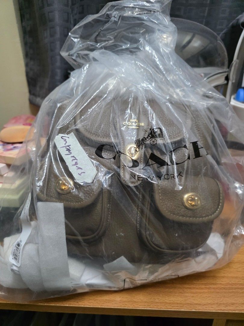 Coach Hadley Backpack in Dark Stone (Category: Luxury Bags & Wallets) located in San Pedro. Submitted by angela.reyes26 (Listing ID 1436925828, Image 1). Description: Original/Authentic Send po ako screenshot ng convo namin sa IG kung san ko binili. Original po. RFS:Masyado maliit sa akin. Bagay ito sa mga petite. - Coach backpack in dark stone color. - Main compartment with drawstring closure. - Two exterior pockets with flap closures. - Gold-to